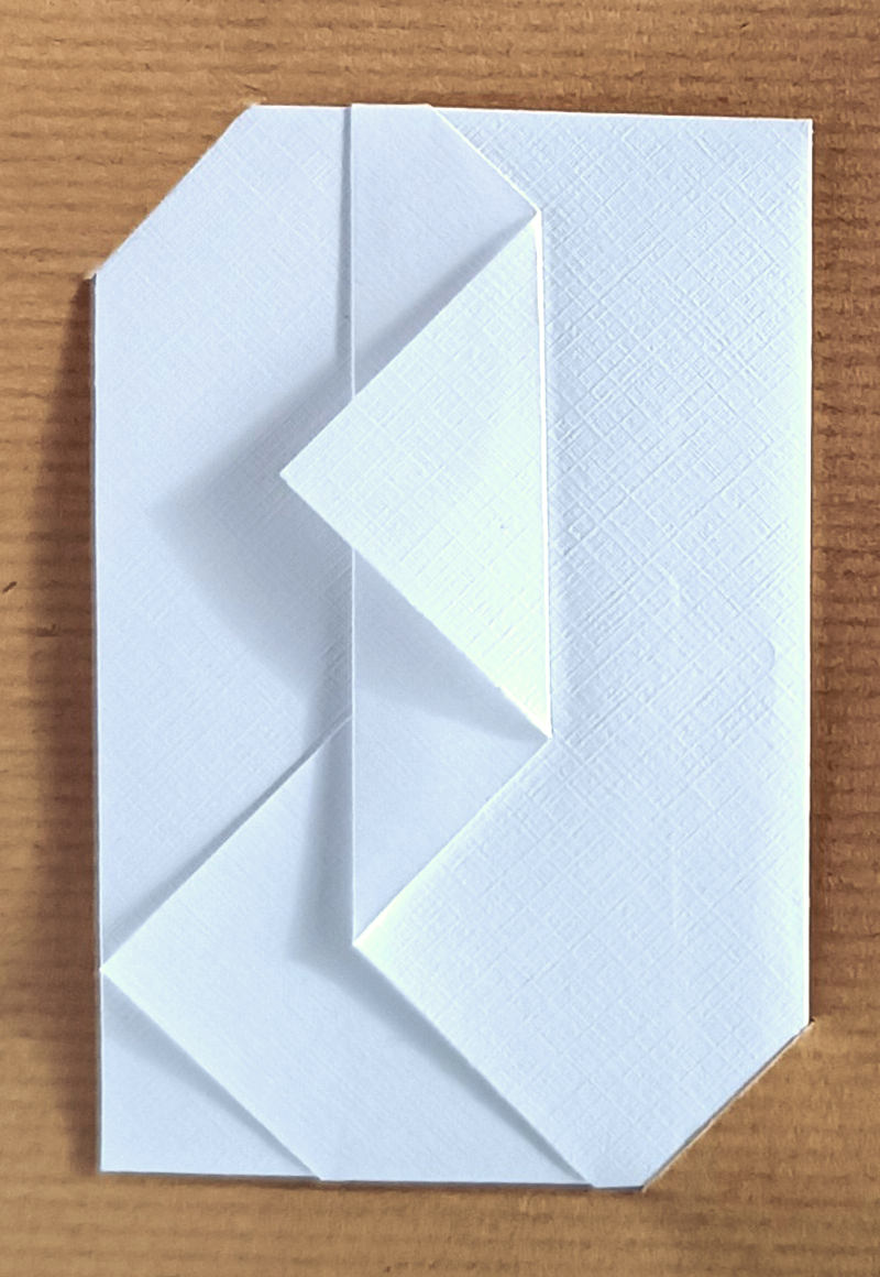 Pochette à étrennes origami en papier texturé blanc avec 2 rabats triangulaires vers la gauche